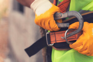 Construction worker attaching carabiner.