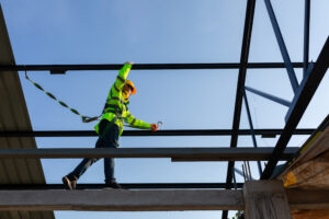 worker wear safety height equipment to install the roof in the construction site;. Fall arrestor device for worker with hooks for safety body harness.