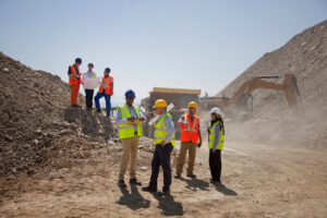 Business people and construction workers talking in quarry