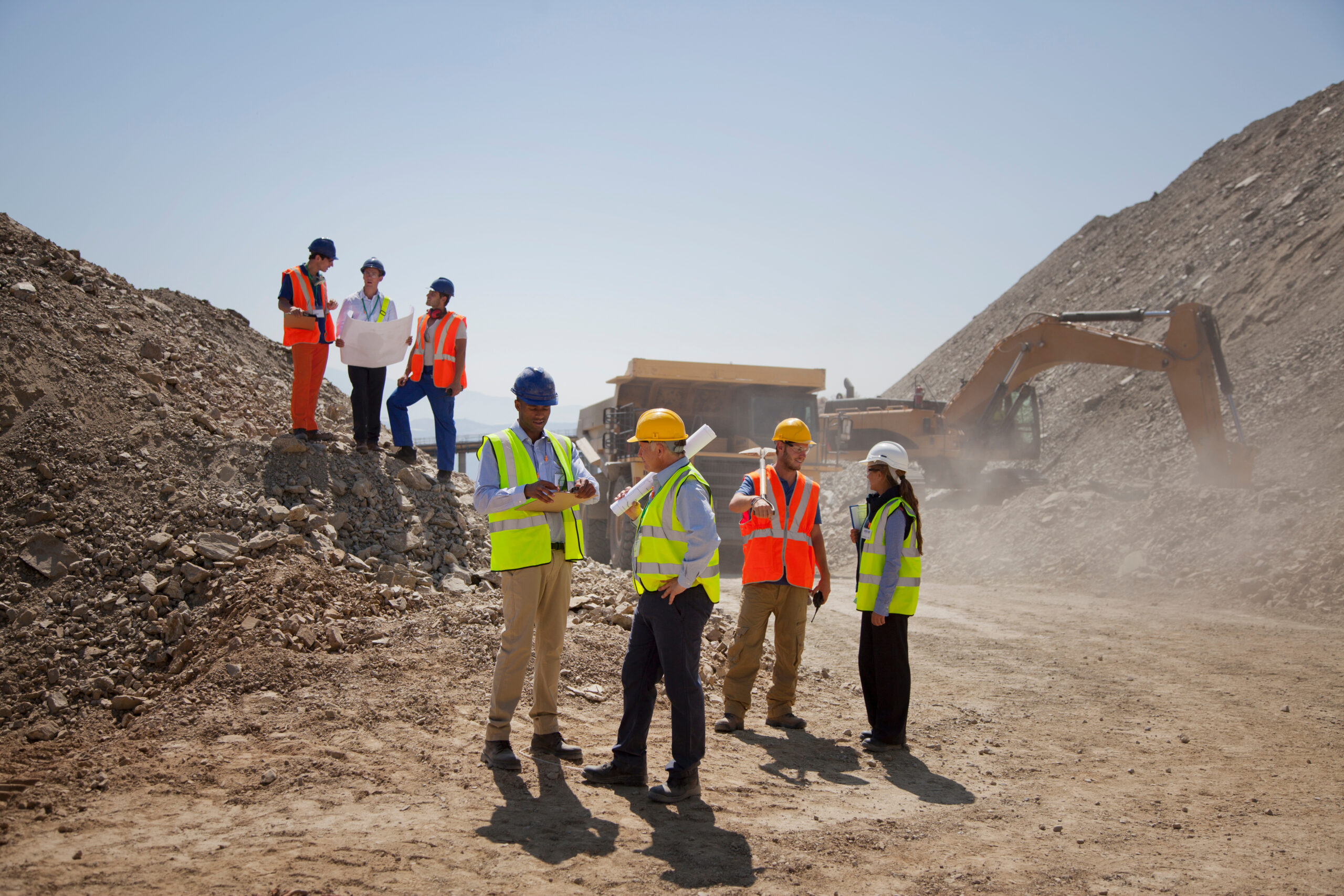 Business people and construction workers talking in quarry
