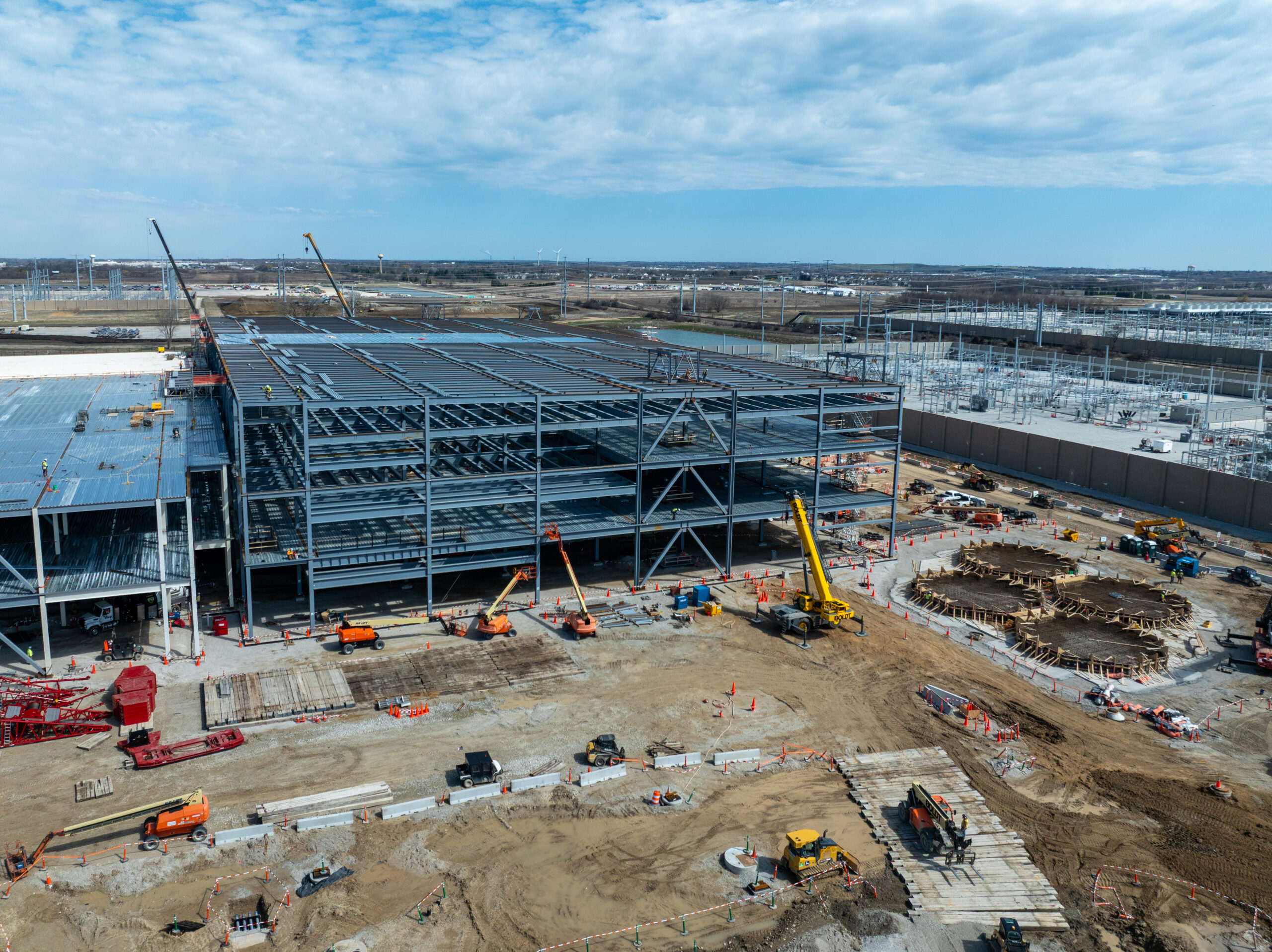 Construction on a Microsoft data center expansion, showing steel framework, cranes, and active development on site.