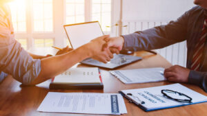 The lawyer is giving legal advice to investors and discussing legal contract documents to be used as a contract between investors signing a consent to invest in doing business together.
