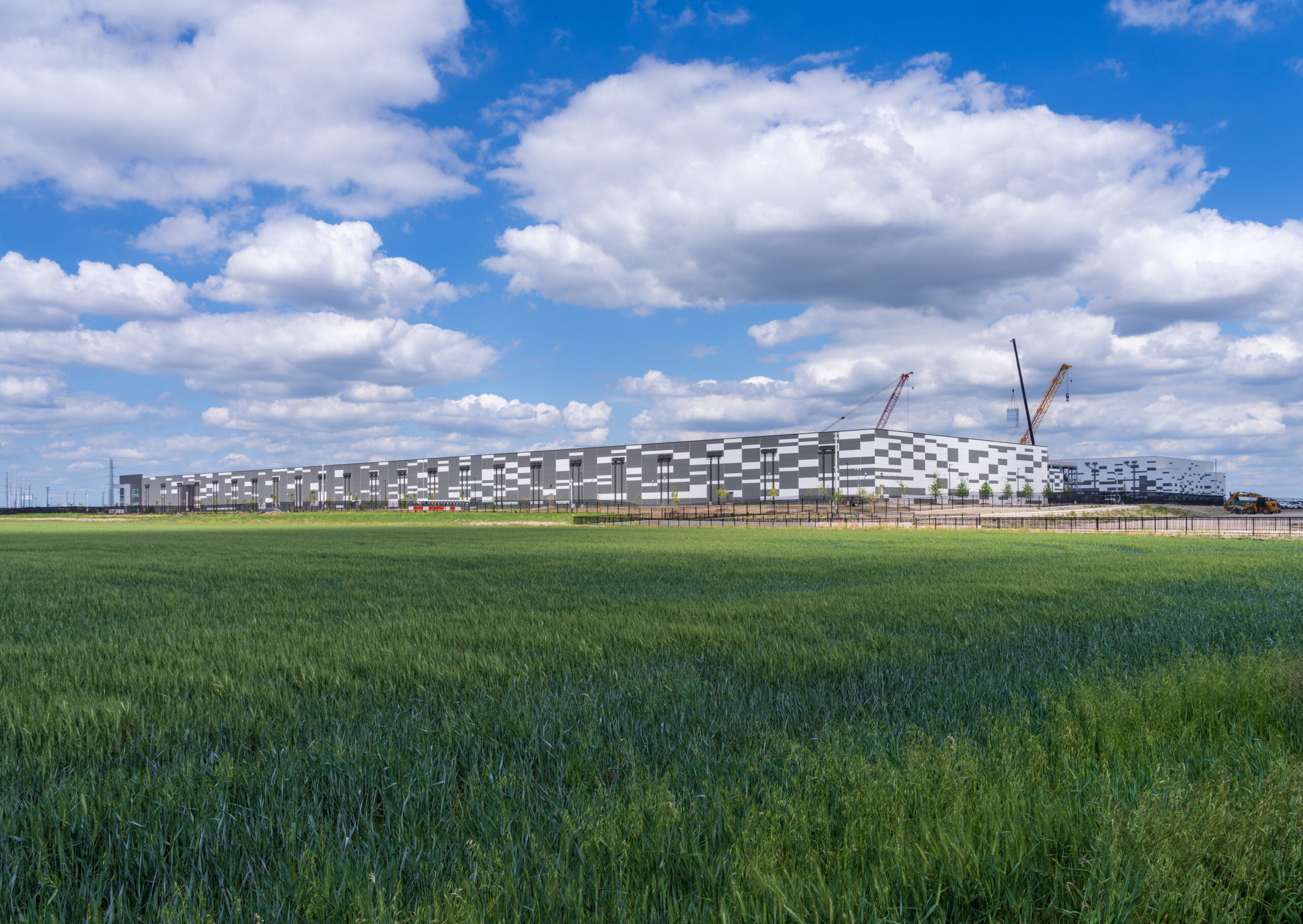 Exterior shot of a data center located in Hutto, Texas. under construction besides rolling fields near Austin